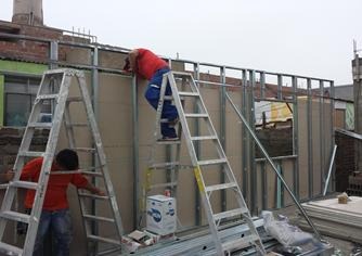 Técnicos especialistas armando muro perimétrico en drywall y perfiles galvanizados